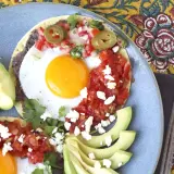 Två huevos rancheros med stekt ägg, svarta bönor, salsa, jalapeños och avokado. En härlig frukost!