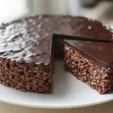 En härlig chokladtårta med krispiga rispuffar och chokladglasyr, perfekt för barnkalas.