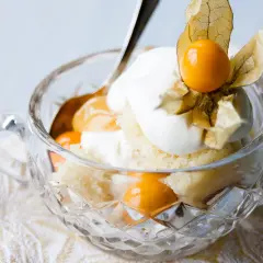 En härlig lemoncurd tårta i en kristallskål, toppad med grädde och physalis. En dröm för alla sötsugna!
