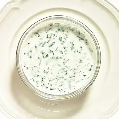 En skål med krämig kall sås till fisk, med finhackade örter som dill och gräslök. Perfekt till sommarens sillunch.