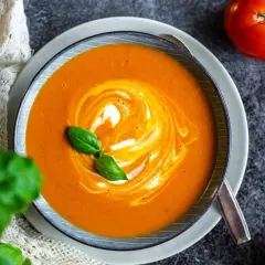 Krämig tomatsoppa med virvlande grädde och färsk basilika. Ett perfekt tomatsoppa recept för en mysig kväll.