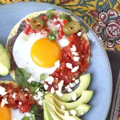 Två huevos rancheros med stekt ägg, svarta bönor, salsa, jalapeños och avokado. En härlig frukost!
