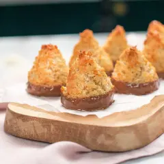 Små, gyllene kokostoppar med chokladbotten, perfekta för ett enkelt kokostoppar recept.