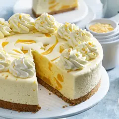 En krämig frozen cheesecake med vispad grädde och passionsfruktssås.
