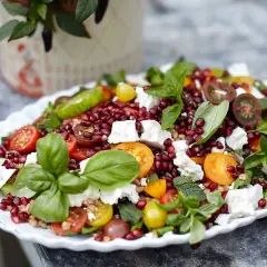 En härlig sallad med granatäpple, tomater, fetaost och färska örter. En riktigt god sallad som ser aptitlig ut.