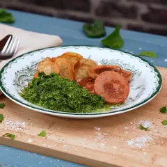 Tallrik med stuvad spenat, stekt falukorv och potatisklyftor. En klassisk svensk måltid.