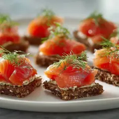 Små snittar med gravad lax på mörkt bröd, toppade med dill. En klassisk svensk delikatess.