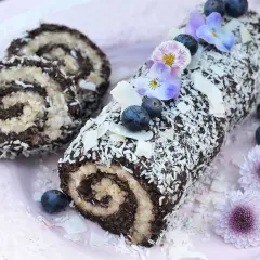 En chokladig rulltårta med kokosflingor, blåbär och blommor. Ett härligt recept på rulltårta från Fredriks fika.