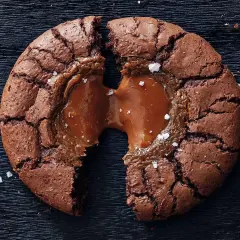 En chokladig brownie cookie med flytande kolakärna, strödd med havssalt.