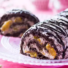 En chokladkaka med aprikosfyllning, perfekt för ett budapestrulle recept. Garnerad med chokladsås och pudersocker.