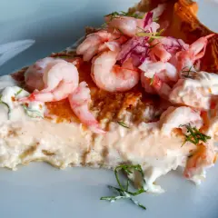 En generös bit räkpaj med krämig fyllning, toppad med saftiga räkor och en hint av västerbottensost.