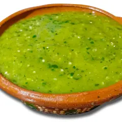 A bowl of vibrant green salsa with visible cilantro and chili pieces.