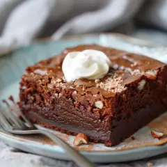 En saftig chokladbrownie med hasselnötter, toppad med grädde. Perfekt för ett brownie recept!