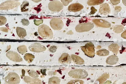 Nära bild av fransk nougat med mandlar, pistagenötter och torkade bär.