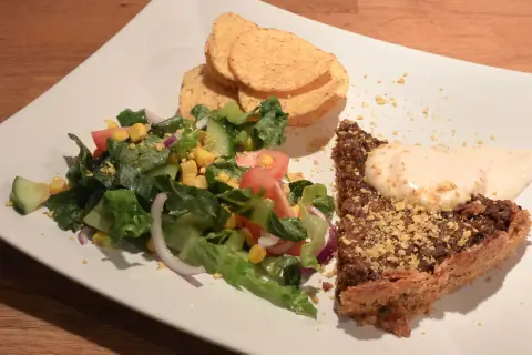 En bit tacopaj med en fräsch sallad till, toppad med krutonger och en klick krämig sås.