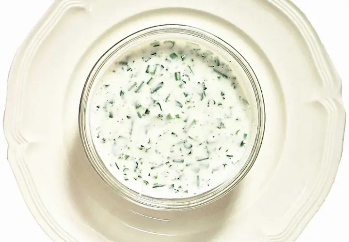 En skål med krämig kall sås till fisk, med finhackade örter som dill och gräslök. Perfekt till sommarens sillunch.