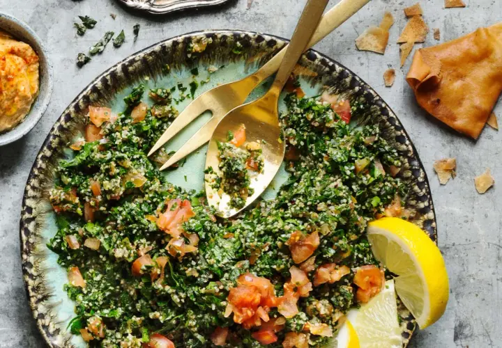 En fräsch tabbouleh med persilja, tomat och bulgur, serverad med citronklyftor och pitabröd. Ett perfekt tabbouleh recept för sommaren.