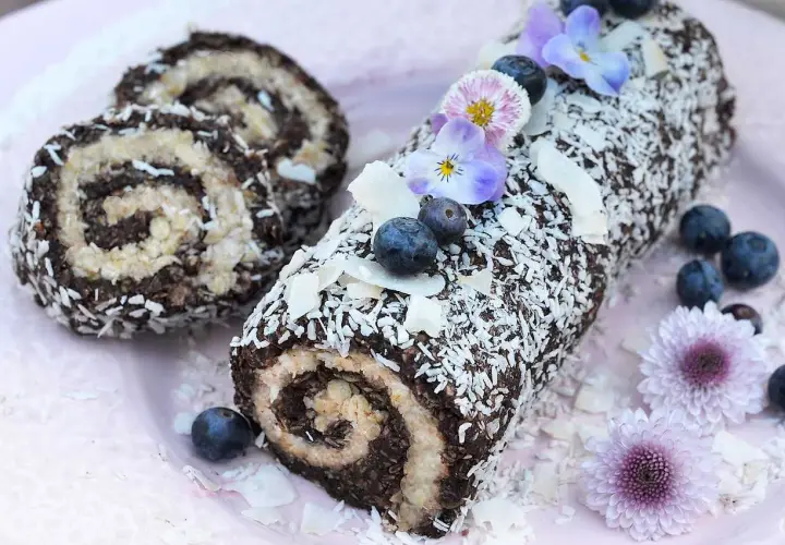 En chokladig rulltårta med kokosflingor, blåbär och blommor. Ett härligt recept på rulltårta från Fredriks fika.