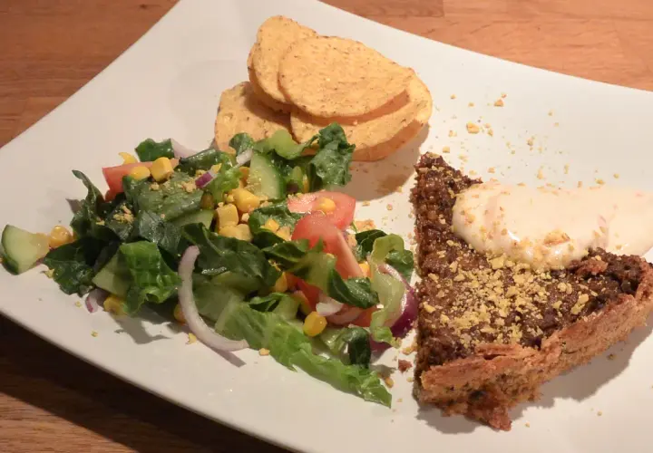 En bit tacopaj med en fräsch sallad till, toppad med krutonger och en klick krämig sås.