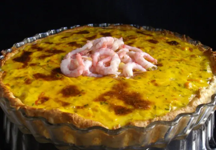 En gyllene räkpaj med en generös topping av saftiga räkor, redo att avnjutas.