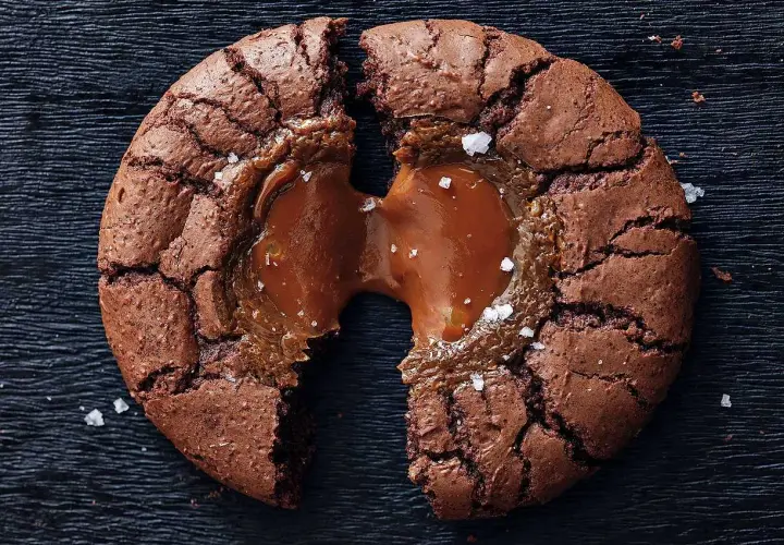 En chokladig brownie cookie med flytande kolakärna, strödd med havssalt.