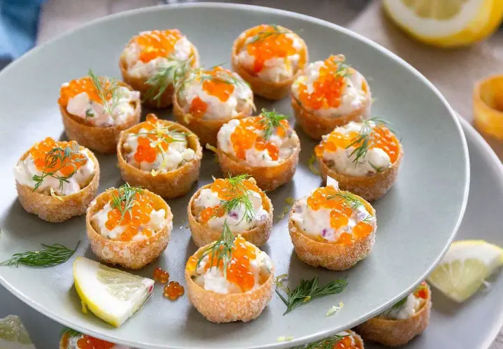 Små, krispiga krustader i ugn fyllda med en krämig röra och toppade med orange rom och dill. Perfekta för mingel!