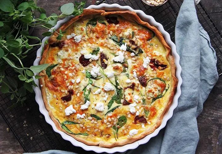 En gyllene, smakrik vegetarisk paj med spenat, soltorkade tomater och pinjenötter. Perfekt för en mysig middag.