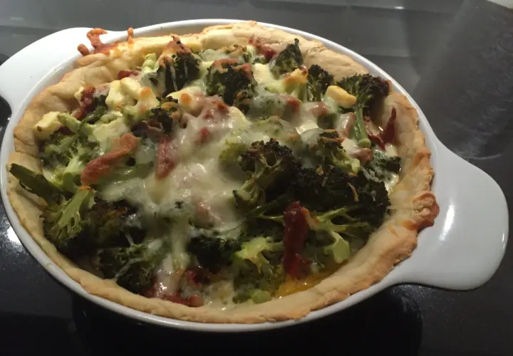 En gyllene vegetarisk paj i långpanna med broccoli och ost.