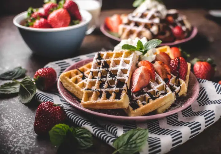 Belgiska våfflor recept: gyllene våfflor med färska jordgubbar, chokladsås och vispgrädde. En perfekt frukost eller dessert.