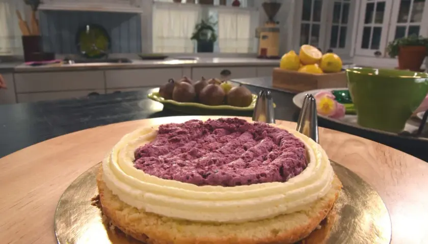 En tårta med fluffig grädde och bärfyllning väntar på att dekoreras. Snart är det dags att baka tårta!