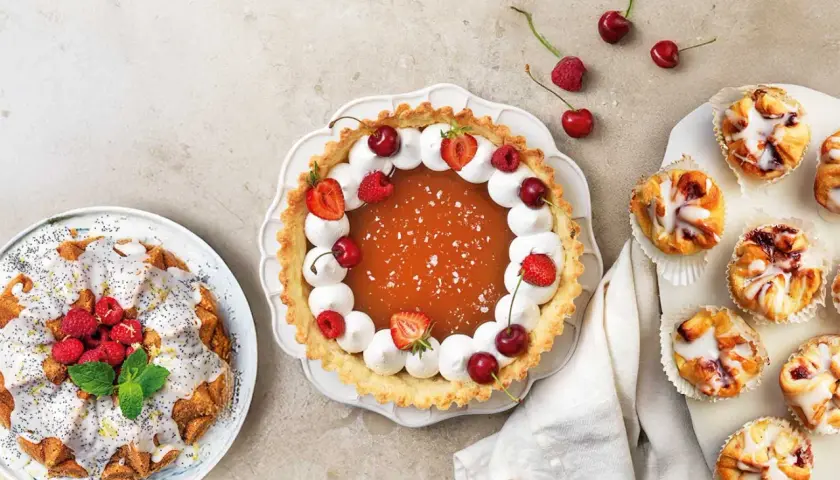 En härlig dukning med en fruktig paj, en sockerkaka med vallmofrön och små bakelser. Perfekt för att baka med flytande margarin!