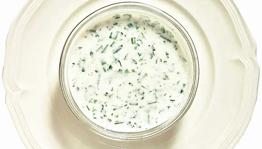 En skål med krämig kall sås till fisk, med finhackade örter som dill och gräslök. Perfekt till sommarens sillunch.