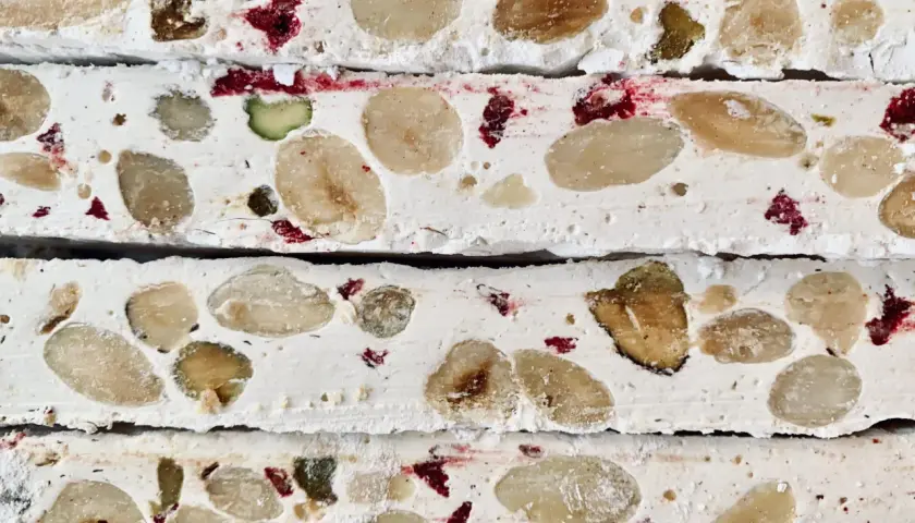 Nära bild av fransk nougat med mandlar, pistagenötter och torkade bär.