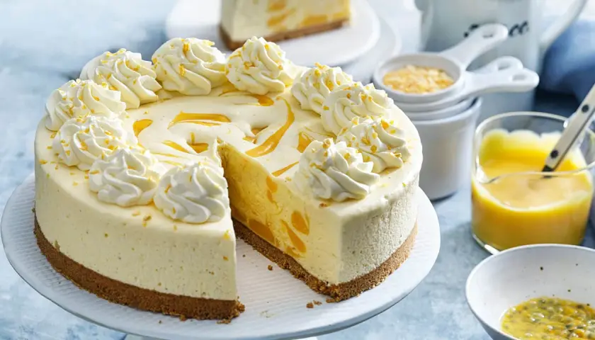 En krämig frozen cheesecake med vispad grädde och passionsfruktssås.