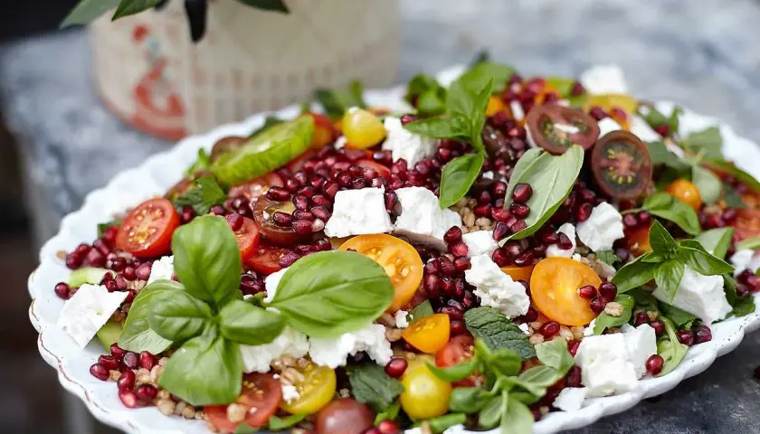 En härlig sallad med granatäpple, tomater, fetaost och färska örter. En riktigt god sallad som ser aptitlig ut.