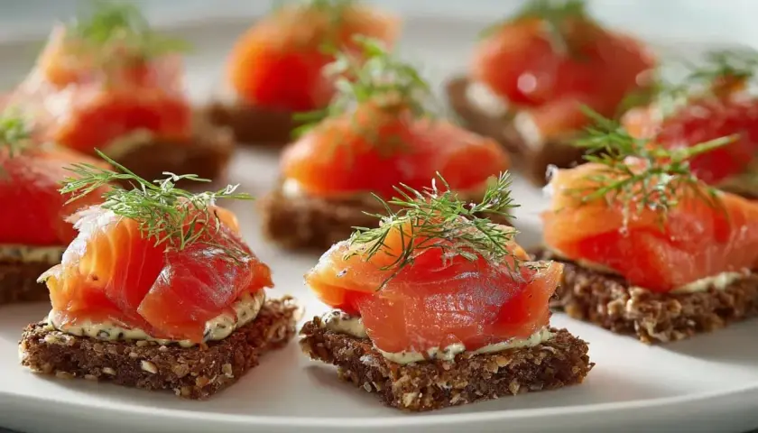 Små snittar med gravad lax på mörkt bröd, toppade med dill. En klassisk svensk delikatess.