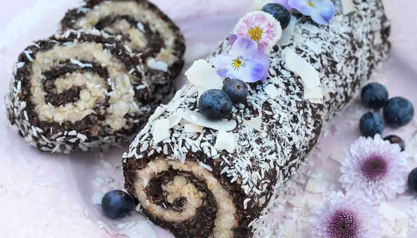 En chokladig rulltårta med kokosflingor, blåbär och blommor. Ett härligt recept på rulltårta från Fredriks fika.