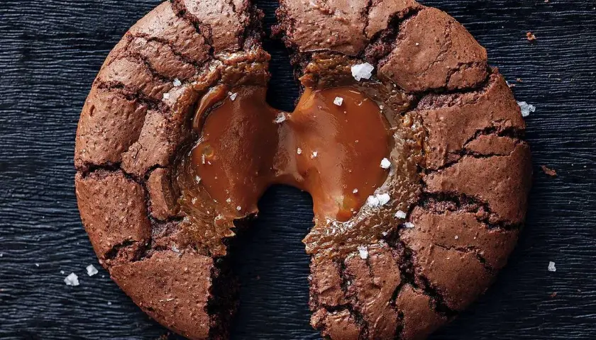 En chokladig brownie cookie med flytande kolakärna, strödd med havssalt.
