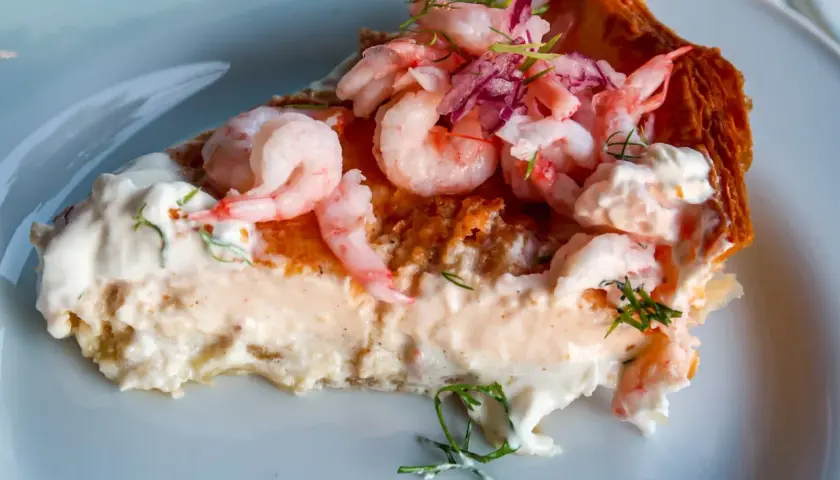 En generös bit räkpaj med krämig fyllning, toppad med saftiga räkor och en hint av västerbottensost.