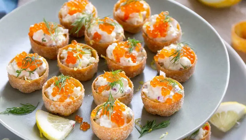 Små, krispiga krustader i ugn fyllda med en krämig röra och toppade med orange rom och dill. Perfekta för mingel!