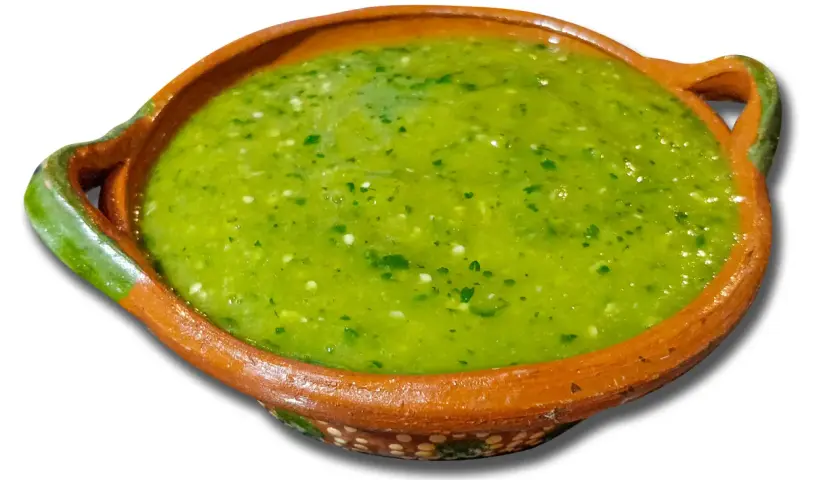 A bowl of vibrant green salsa with visible cilantro and chili pieces.
