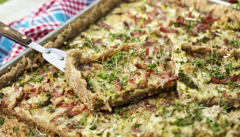 En gyllene kycklingpaj i långpanna, toppad med krispigt bacon och färska örter. Perfekt för en somrig picknick.