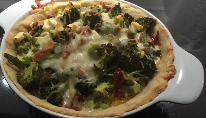 En gyllene vegetarisk paj i långpanna med broccoli och ost.