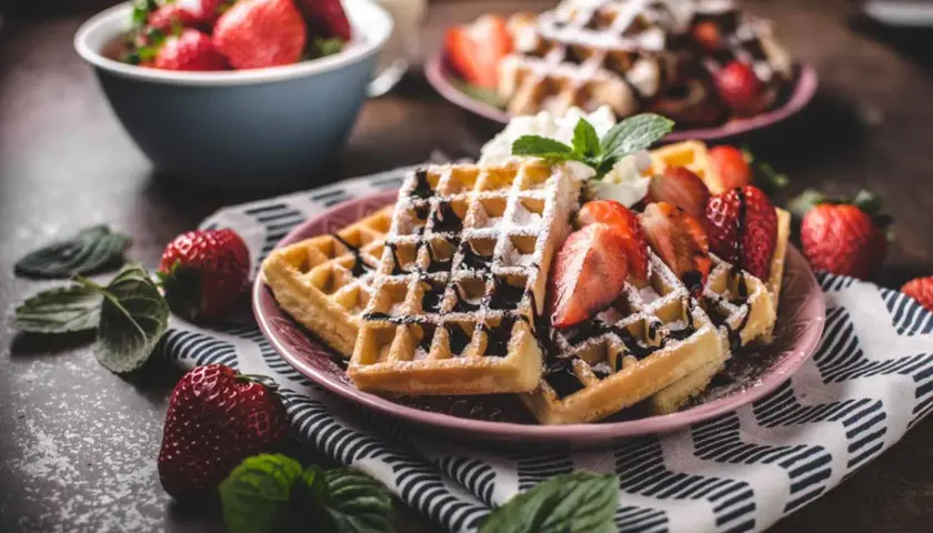 Belgiska våfflor recept: gyllene våfflor med färska jordgubbar, chokladsås och vispgrädde. En perfekt frukost eller dessert.