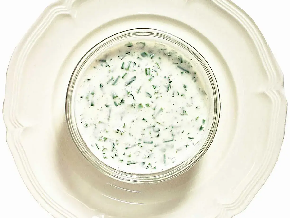 En skål med krämig kall sås till fisk, med finhackade örter som dill och gräslök. Perfekt till sommarens sillunch.