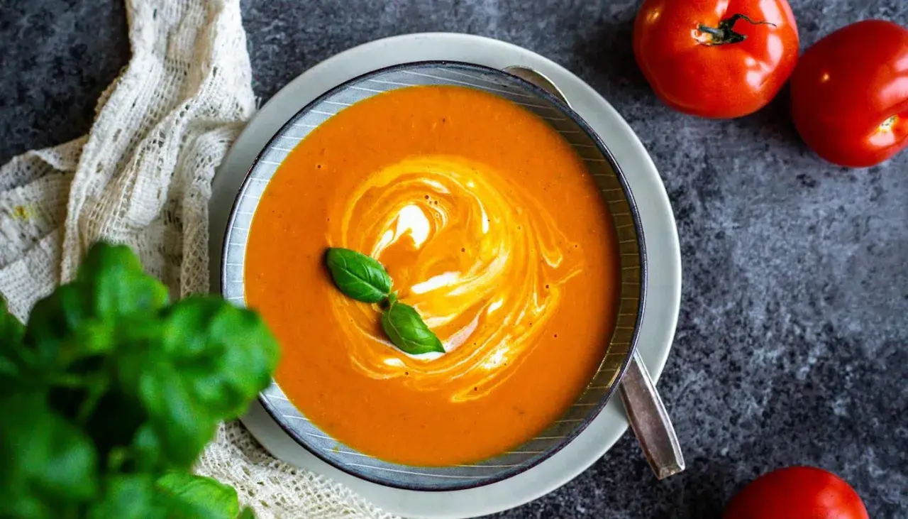 Krämig tomatsoppa med virvlande grädde och färsk basilika. Ett perfekt tomatsoppa recept för en mysig kväll.