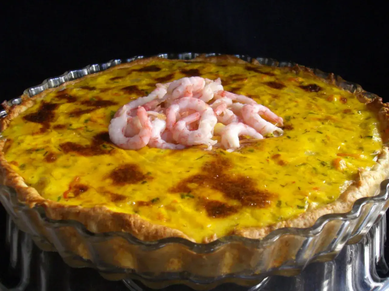 En gyllene räkpaj med en generös topping av saftiga räkor, redo att avnjutas.