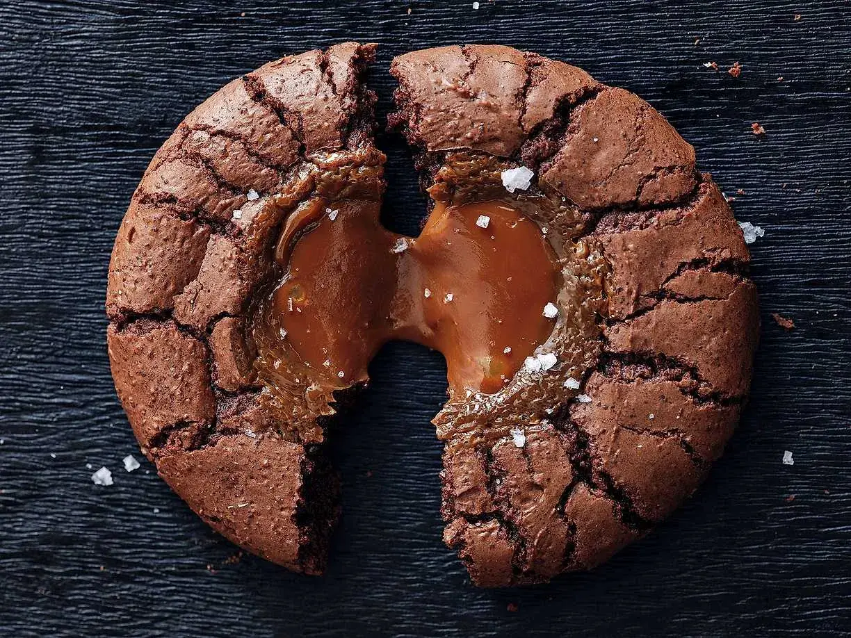 En chokladig brownie cookie med flytande kolakärna, strödd med havssalt.