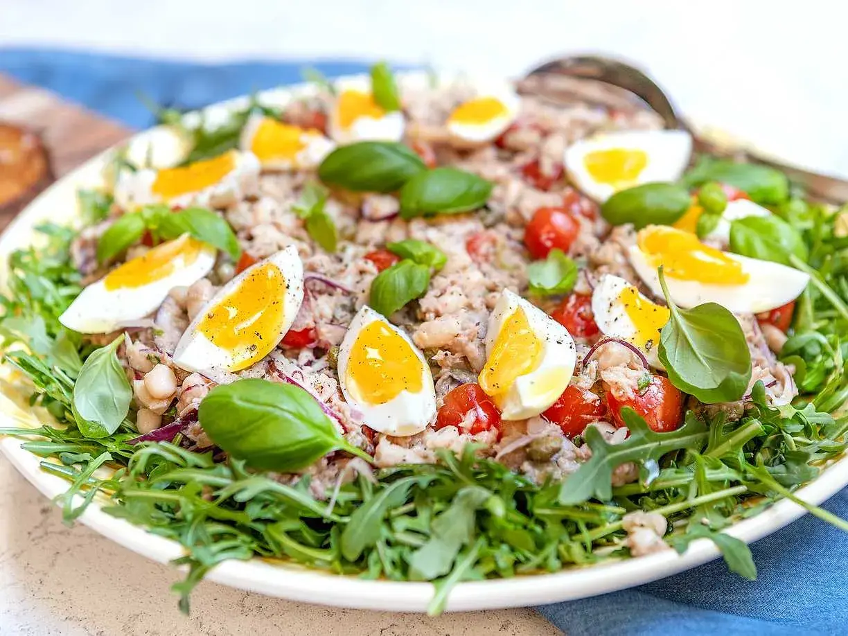 En härlig tonfisksallad med kokta ägg, körsbärstomater, bönor och basilika, perfekt som en lätt lunch eller middag.