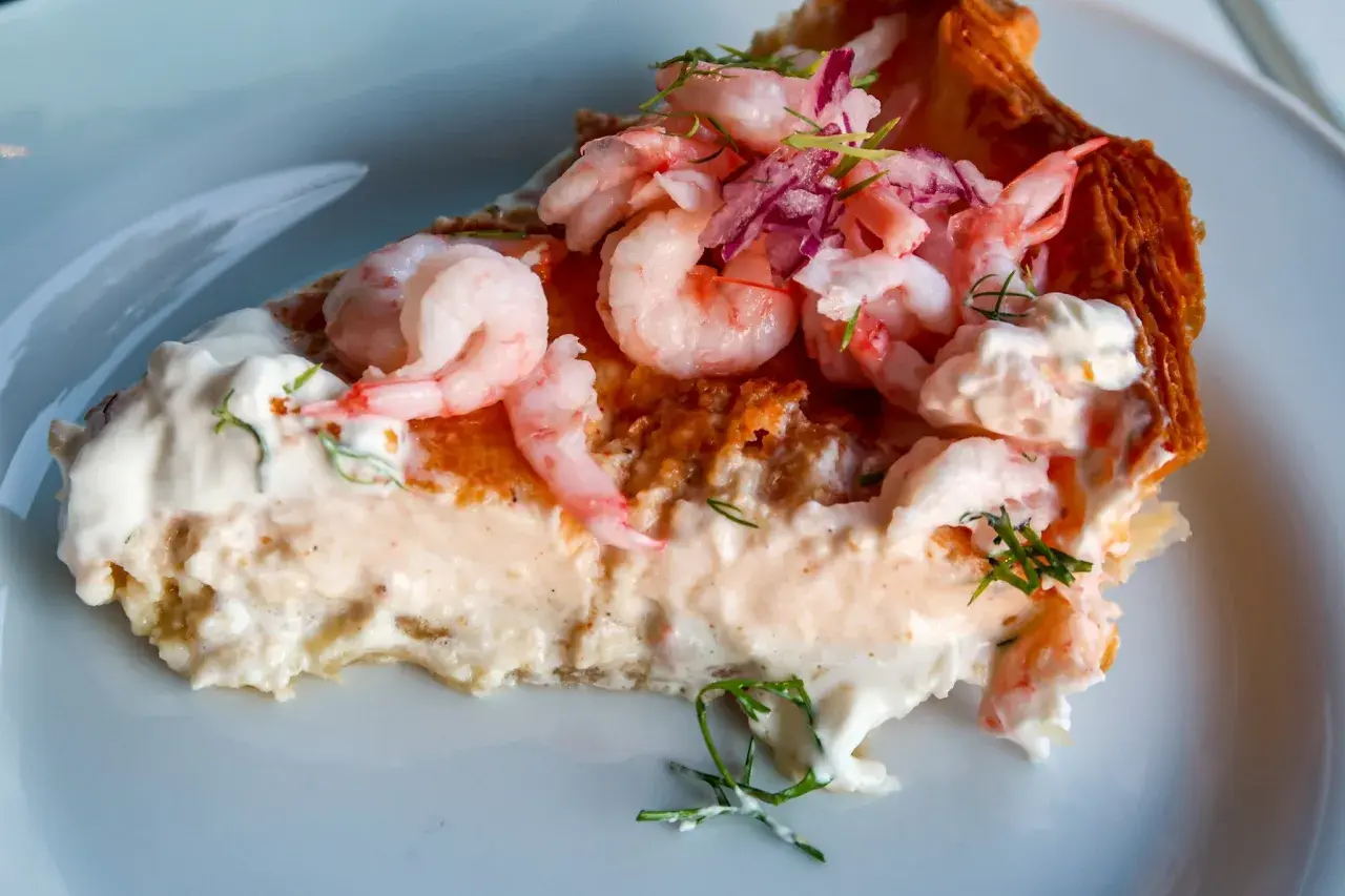 En generös bit räkpaj med krämig fyllning, toppad med saftiga räkor och en hint av västerbottensost.